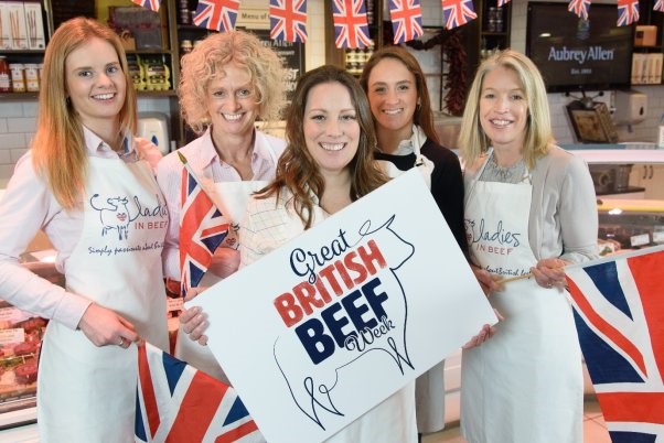 Five women posing in a butcher shop with GBBW merchandise.